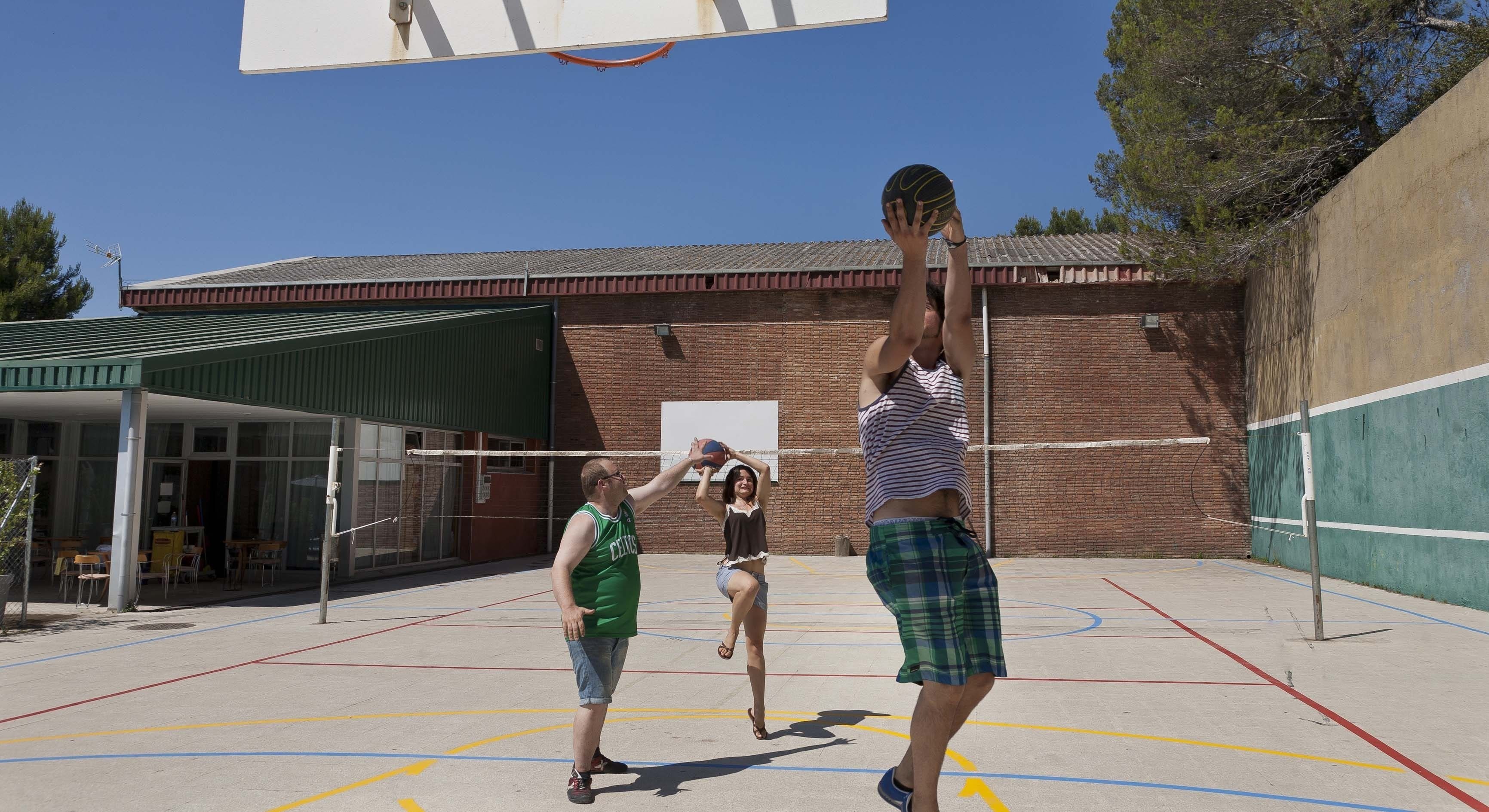 An outdoor basketball court with a building in the background.