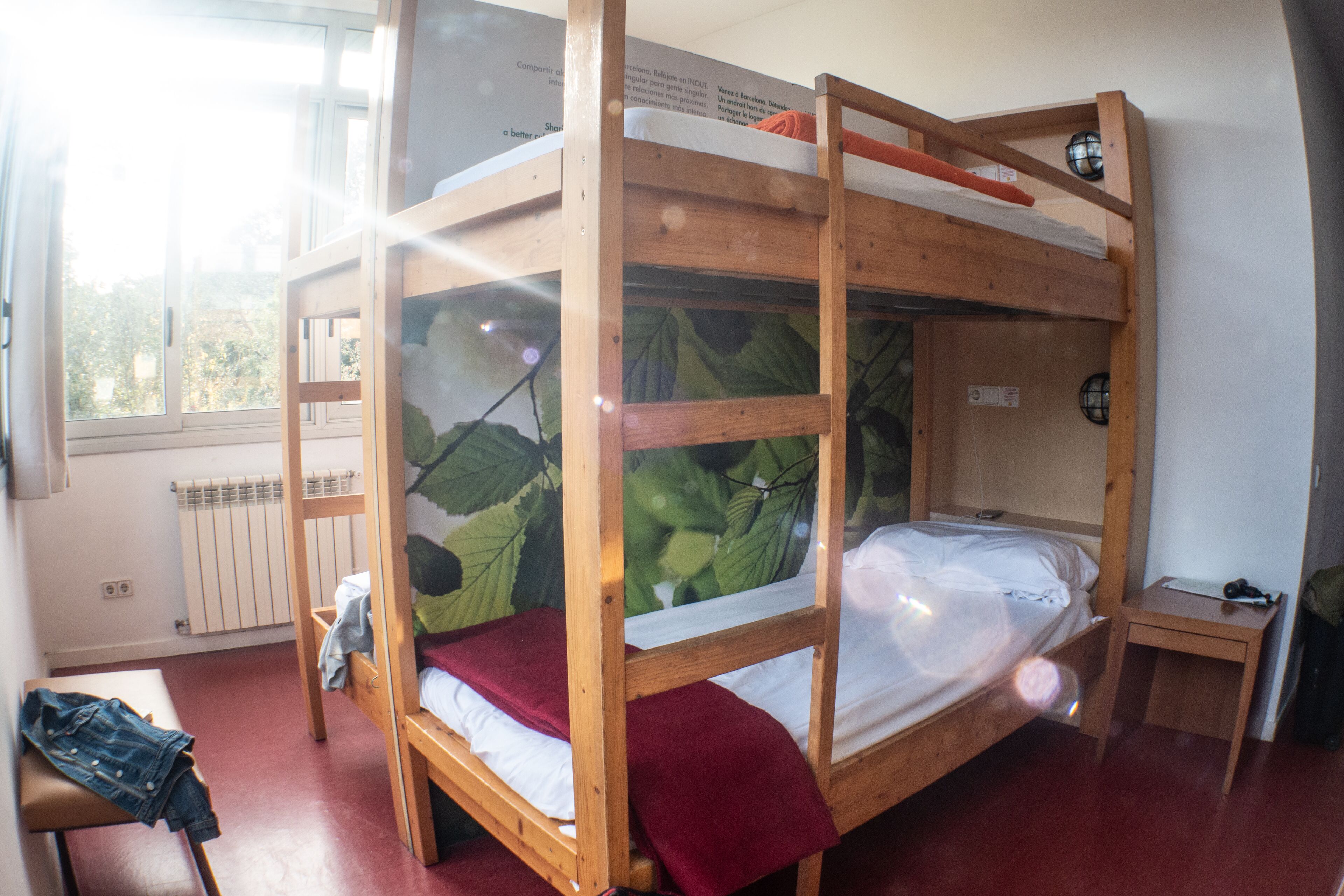 Ein Schlafraum mit Etagenbett, Fenster und einem kleinen Tisch.