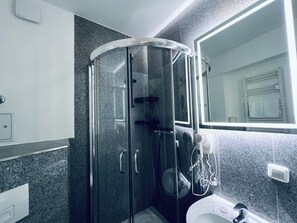 Douche, douche à « effet pluie », sèche-cheveux, serviettes fournies
