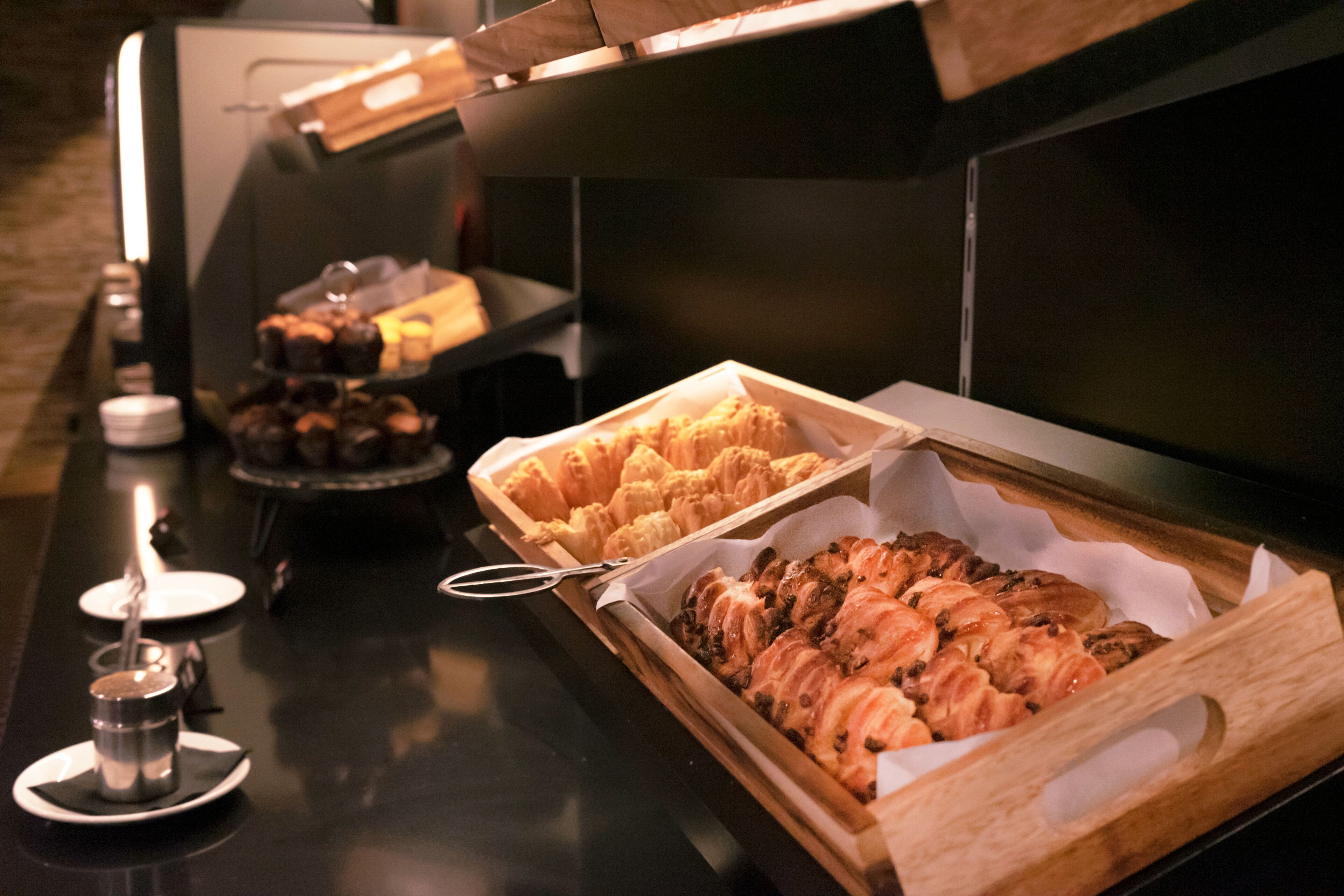 A buffet with various baked goods and a coffee station.