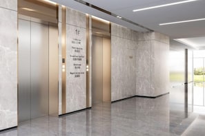 A modern elevator with a marble wall and a digital display indicating floor 1F. - Blue Peninsula Hotel (Xiamen)