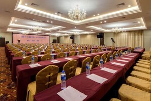 A conference room with rows of tables and chairs, equipped with water bottles and name cards. - Blue Peninsula Hotel (Xiamen)
