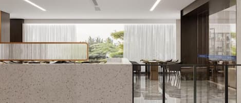 A modern interior with a reception desk, seating area, and large windows.