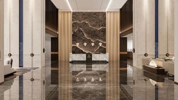 Um hall de hotel moderno com uma recepção de mármore, área de estar e uma parede grande com padrão decorativo.
