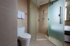A modern bathroom with a glass-enclosed shower, a toilet, and a sink. - Blue Peninsula Hotel (Xiamen)