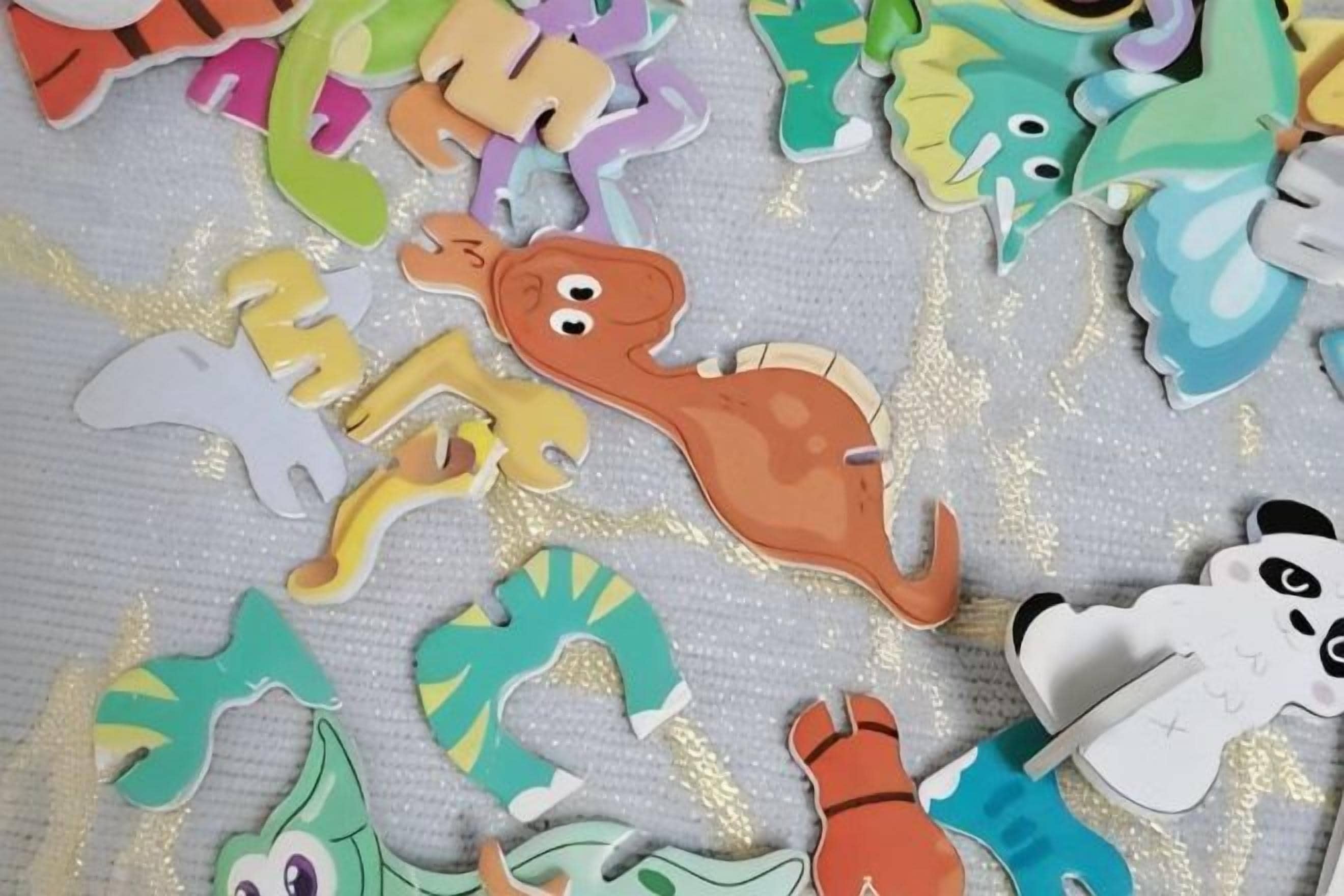Una colección de figuras de animales de colores recortadas sobre una superficie texturizada.
