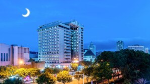 Un hotel moderno de gran altura, con varios pisos, balcones y una estructura cúpula destacada.