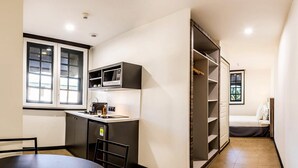 A compact kitchen with a dining area, a built-in microwave, and a small refrigerator. - Fort Savane (Fort-de-France)