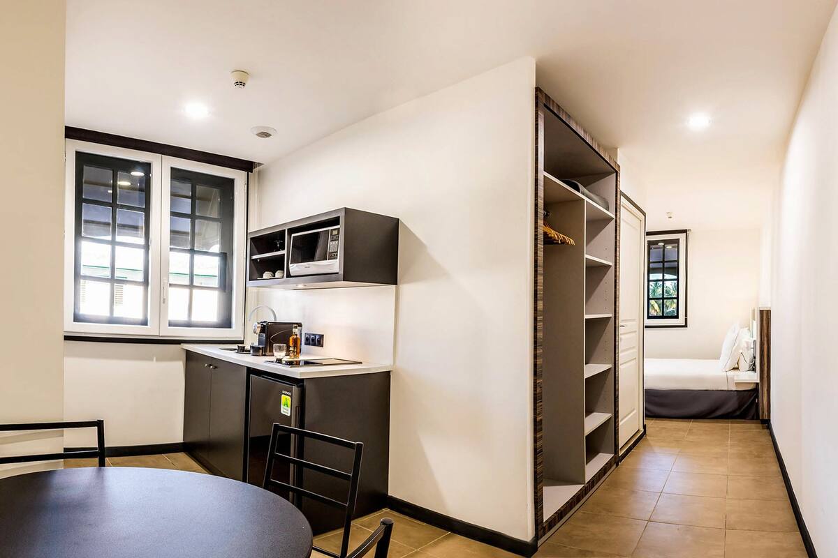 A compact kitchen with a dining area, a built-in microwave, and a small refrigerator.