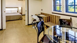 A hotel room with a bed, a desk, a chair, a glass table, and a window with a view. - Fort Savane (Fort-de-France)