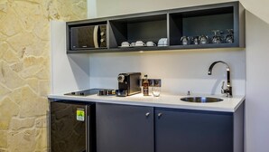 A compact kitchen with a built-in oven, a coffee machine, and a sink. - Fort Savane (Fort-de-France)