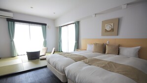 Una habitación de hotel con una cama grande, una silla, una mesita y un reloj de pared.