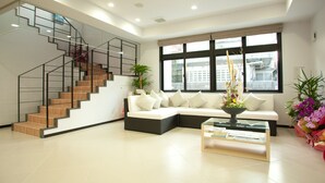 Una sala de estar moderna con una escalera, un sofá modular y una mesa de centro.