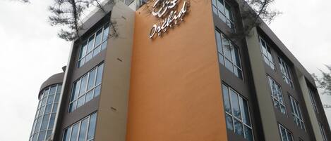 A hotel with a prominent orange vertical sign reading "The Orchid Hotel."