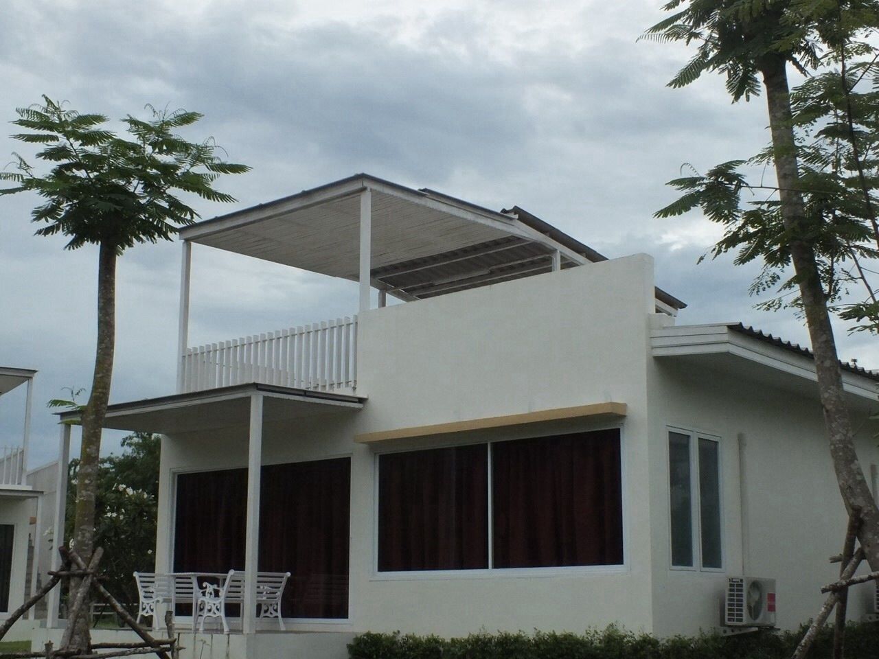 Un immeuble de deux étages doté d’un balcon et de grandes fenêtres.