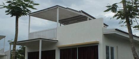 Un immeuble de deux étages doté d’un balcon et de grandes fenêtres.