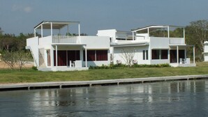 A modern two-story house with a flat roof, large windows, and a balcony. - Worawee Resort & Spa (Kaeng Krachan)