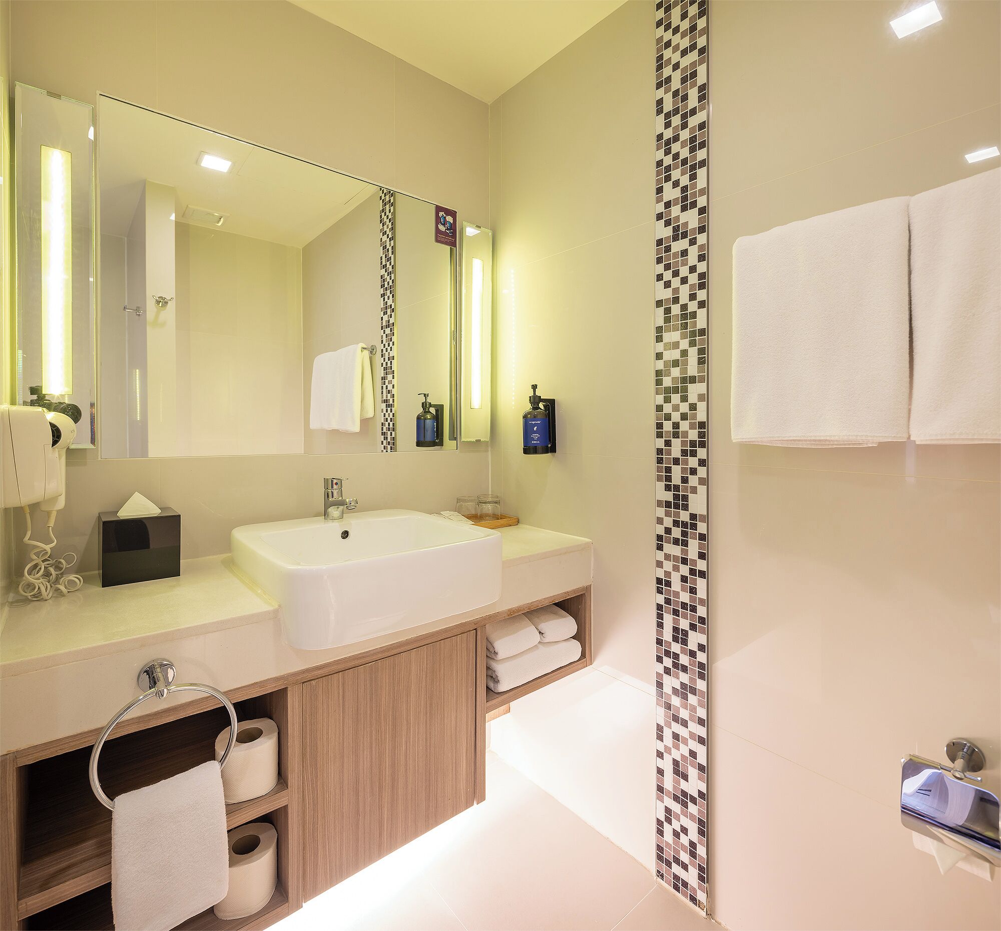 A modern bathroom with a large sink, mirror, and a shower area.