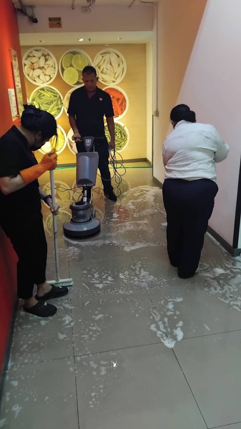Un pasillo con una máquina para limpiar pisos, un trapeador y una escoba.