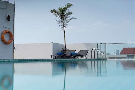 Una piscina al aire libre, sillones reclinables de piscina