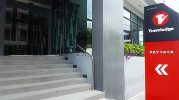 Una escalera que lleva a un edificio con un letrero de Travelodge Pattaya.