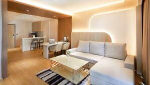 Uma sala de estar moderna com sofá, mesa de centro e área de jantar com cadeiras e mesa.