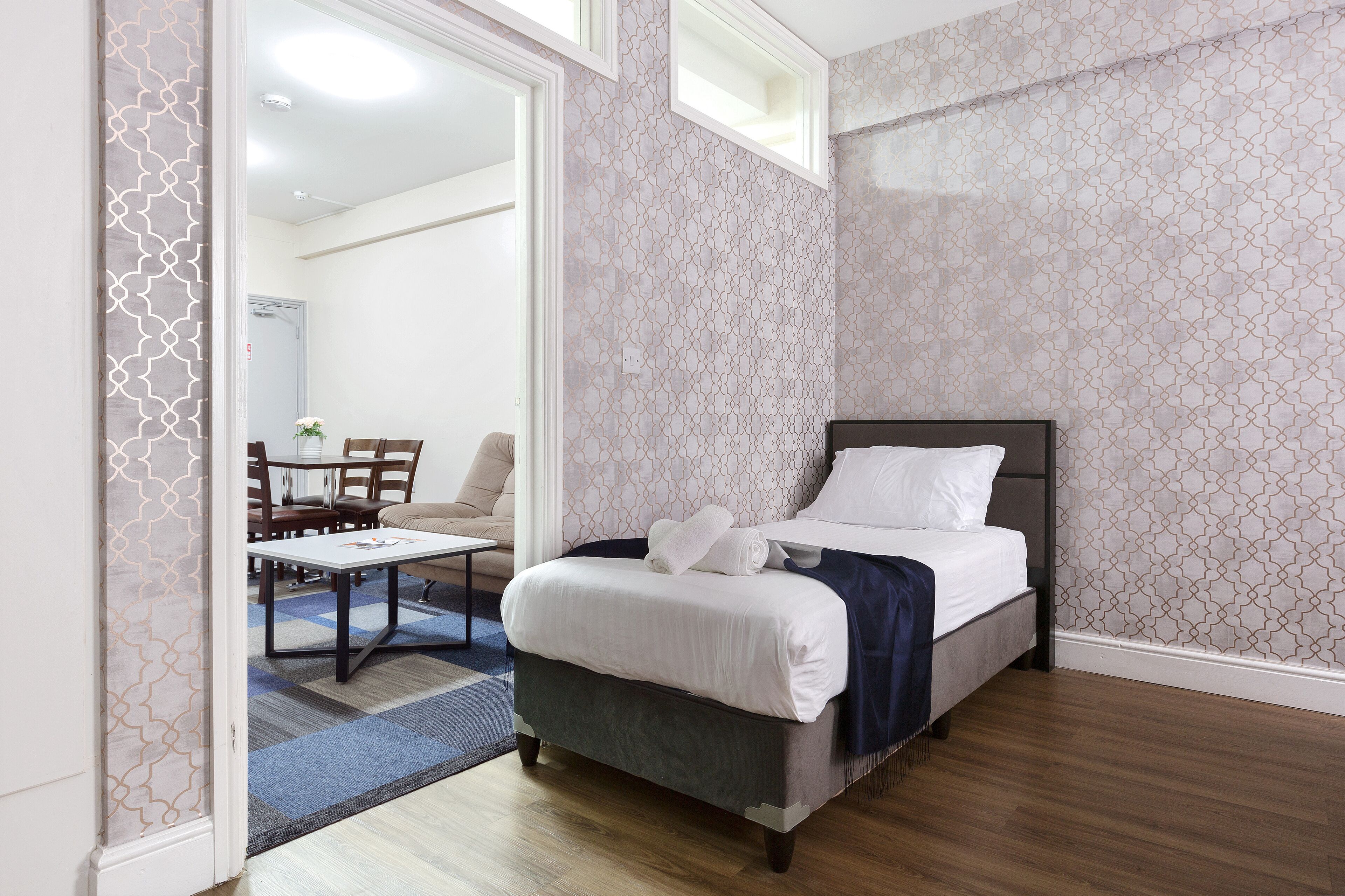 A bedroom with a bed, a desk, and a chair.