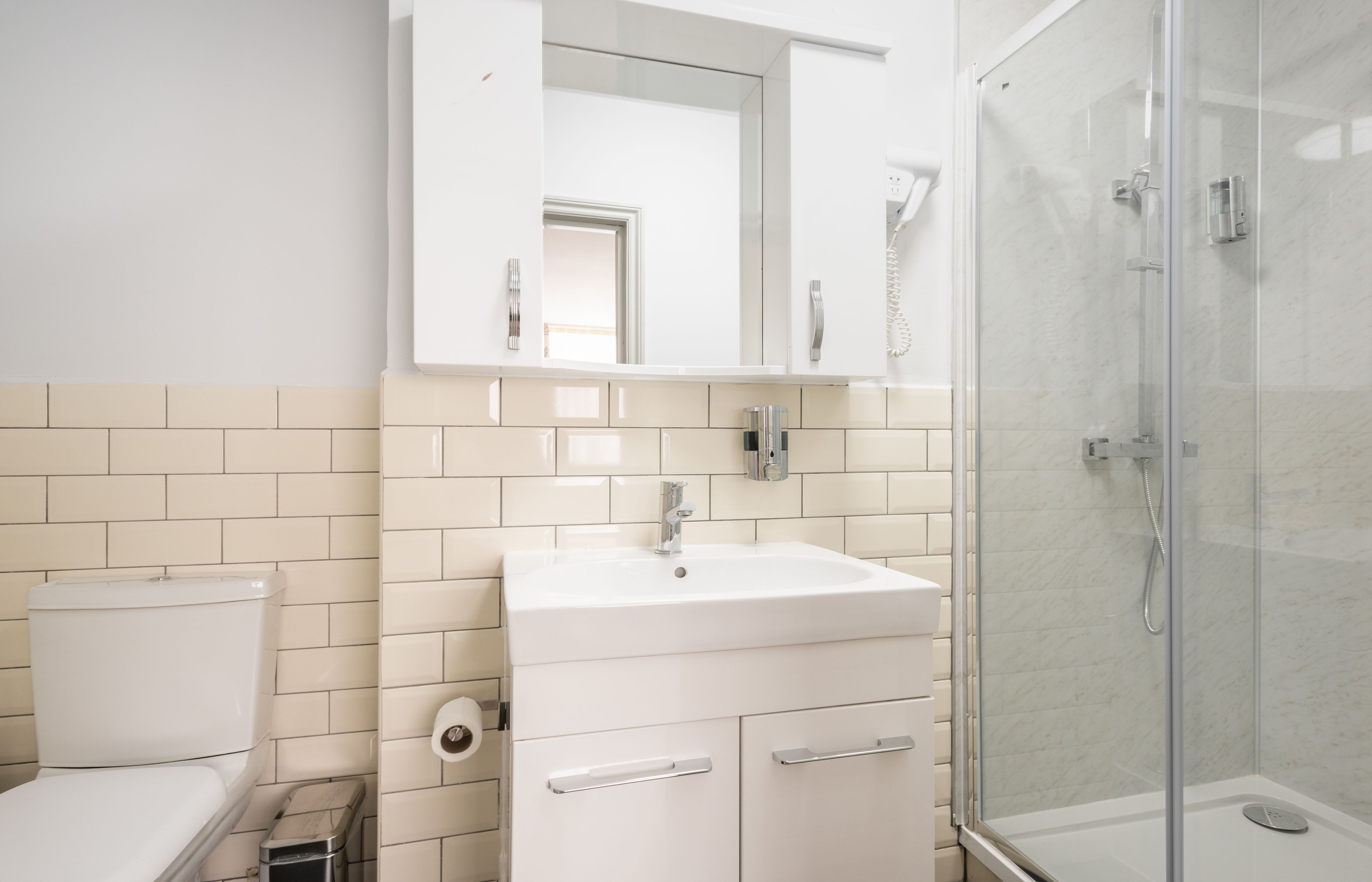 Un bagno con un WC, un lavandino e una cabina doccia in vetro.