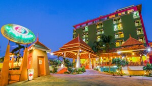 A hotel with a prominent sign, a covered entrance, and a pool area. - Phuphaya Resort Pattaya (Pattaya)