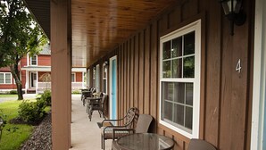 A covered outdoor seating area with tables and chairs, a wooden exterior, and a number '4' on the wall. - Blue Hill Lodge (Claryville)