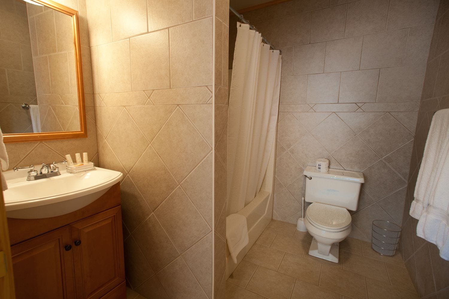 A bathroom with a sink, toilet, and shower area.