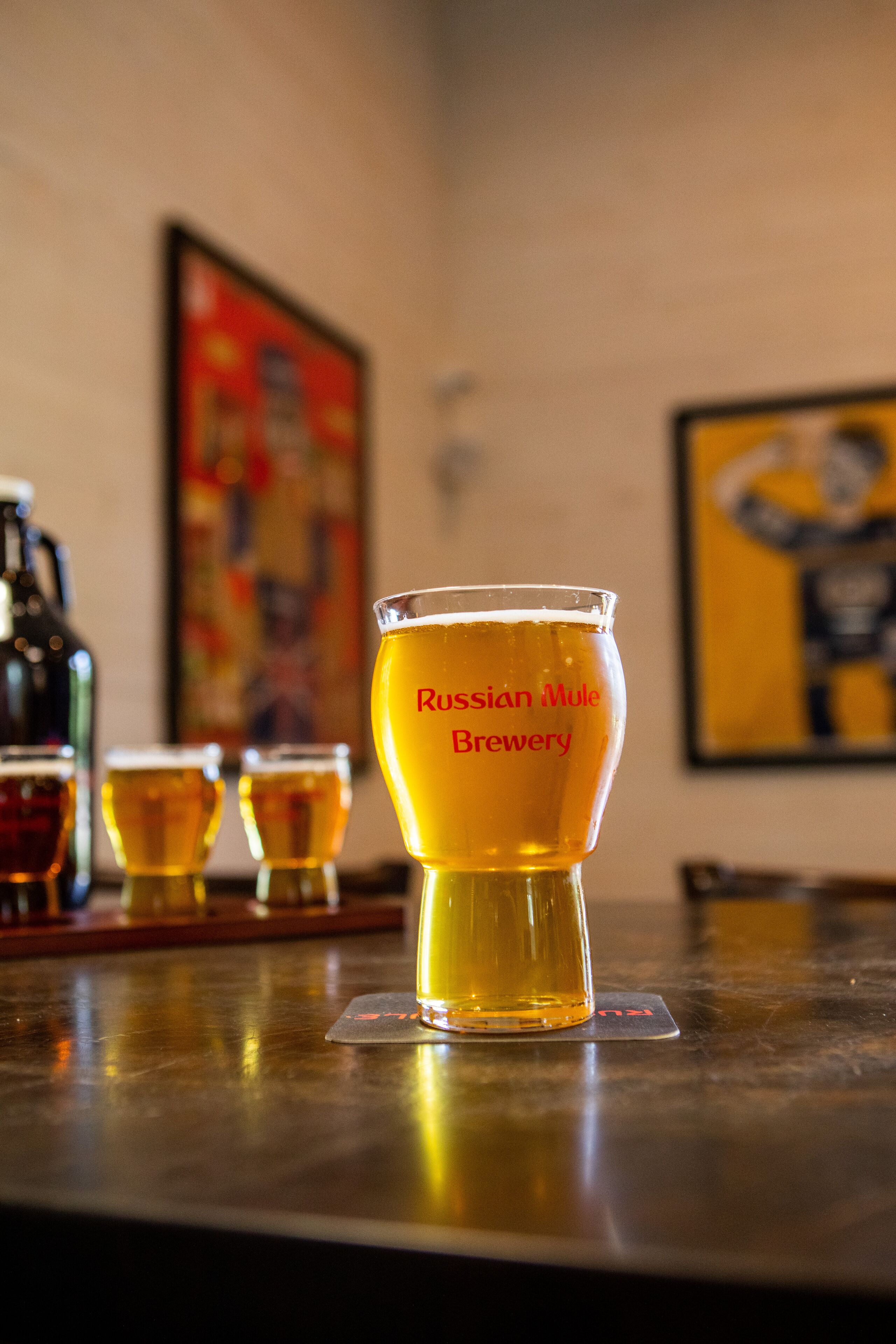 Un bar con un vaso que muestra la etiqueta 'Russian Mule Brewery'.