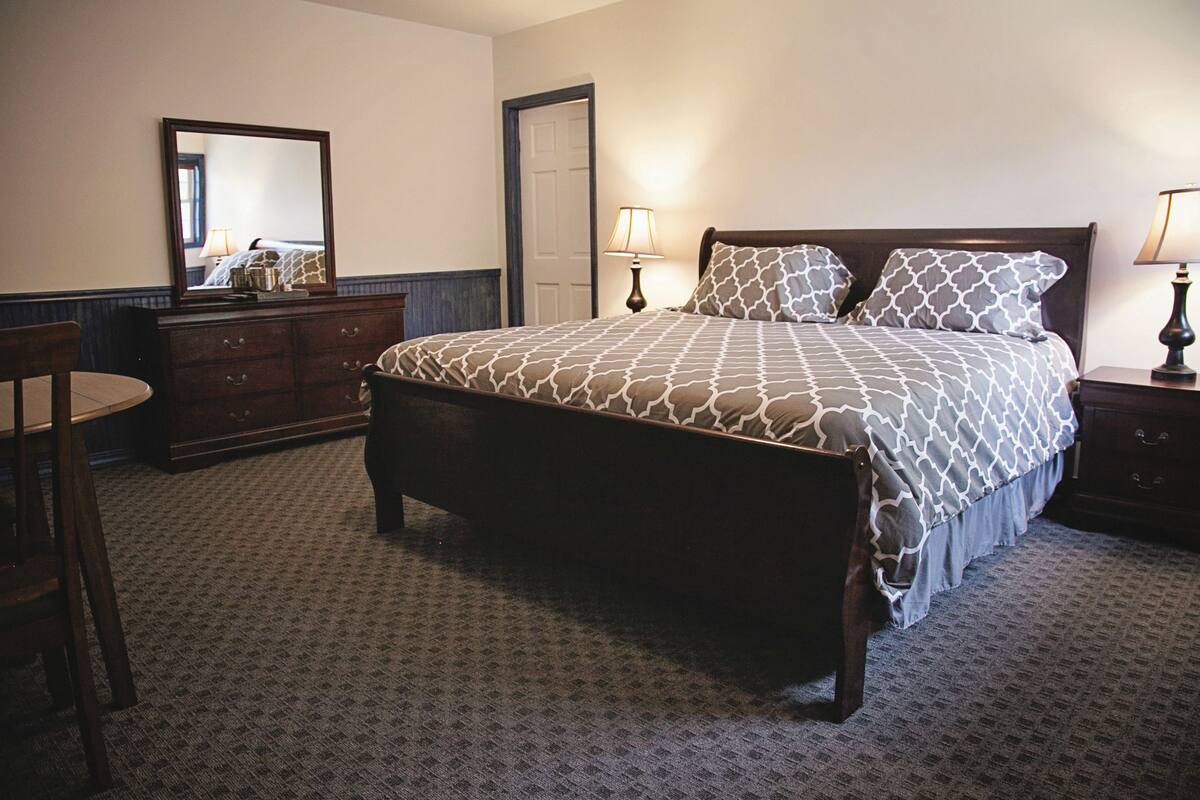 Une chambre bien rangée, avec un lit, une commode et une chaise.