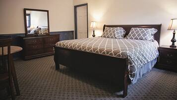 A neatly arranged bedroom with a bed, dresser, and chair.