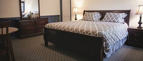 A neatly arranged bedroom with a bed, dresser, and chair.
