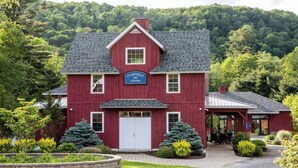 A red barn-style building labeled as 'Claryville Art Center' with a covered outdoor seating area. - Blue Hill Lodge (Claryville)