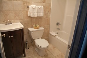 A bathroom with a toilet, sink, and bathtub. - Blue Hill Lodge (Claryville)