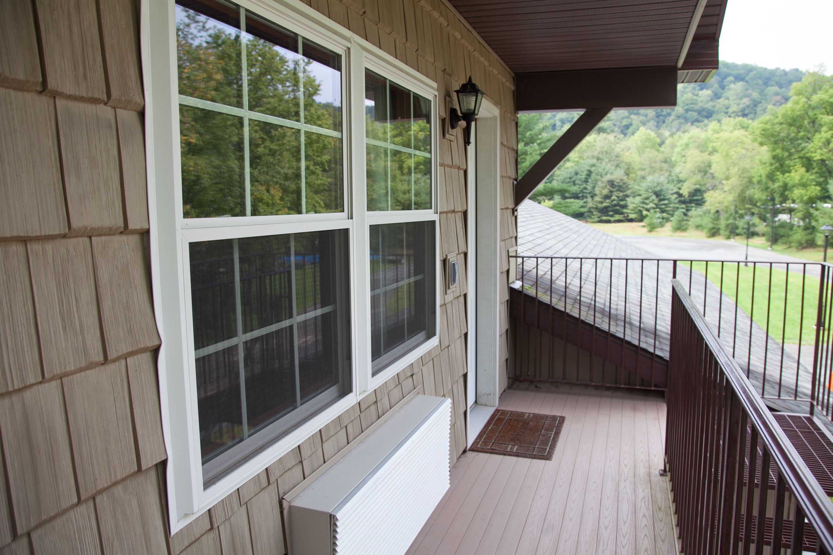 A covered porch with a view of a green landscape.