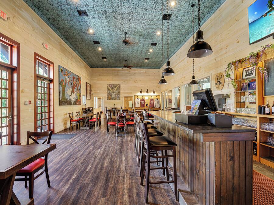 A restaurant interior with wooden walls, a bar area, and a ceiling with intricate patterns.