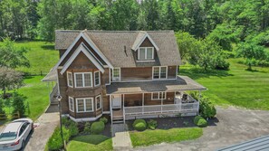 A two-story house with a porch, a garage, and a well-maintained lawn. - Blue Hill Lodge (Claryville)