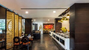 Um restaurante moderno com um balcão extenso, painéis decorativos e um mural na parede do fundo.