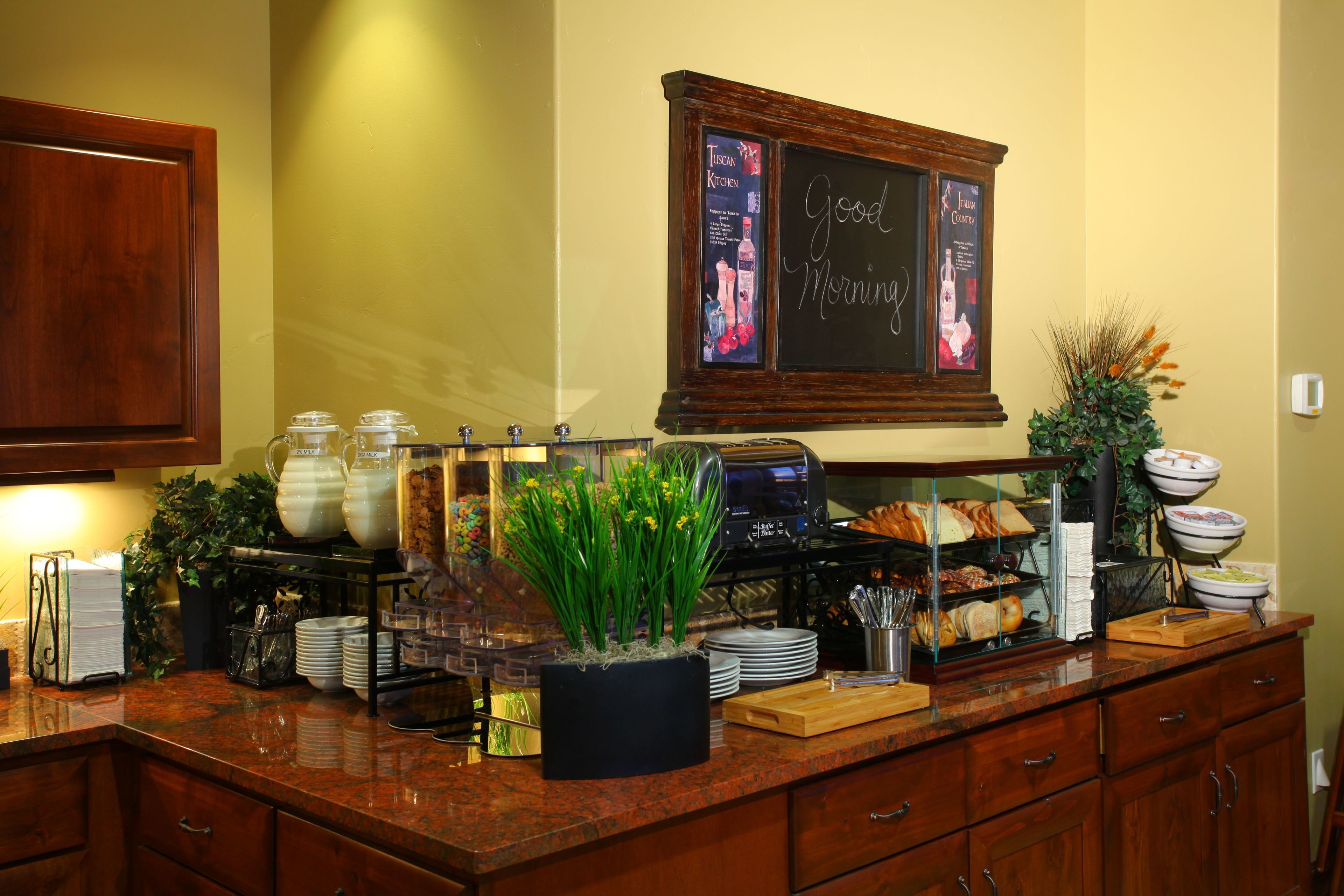 A breakfast bar with a coffee machine, a menu board, and various breakfast items.