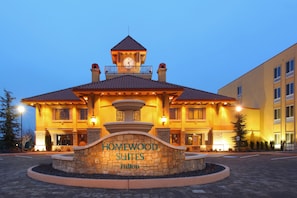 Un hotel con fachada de piedra, una torre del reloj y un cartel que dice "Homewood Suites Hilton".