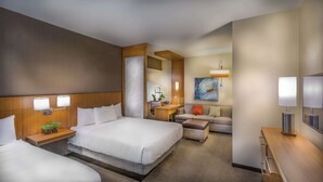 Une chambre d’hôtel avec un grand lit, un bureau, un canapé et une télévision.