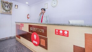 A reception desk with a clock, a framed picture, and a fire extinguisher. - Hotel Udupi Park Inn (Bengaluru)