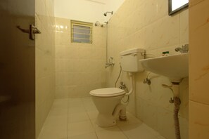 A small, clean bathroom with a toilet, sink, and shower. - Hotel Udupi Park Inn (Bengaluru)