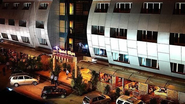 A modern building with a unique architectural design, featuring a series of balconies and a ground-level restaurant area. - Hotel Ekaa (Bengaluru)