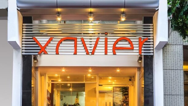 A hotel entrance with a modern design, featuring a prominent 'Xavier' sign above the entrance. - Xavier Hotel (Ho Chi Minh City)