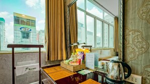 A hotel reception desk with a view of the cityscape, a window with curtains, and a kettle on the counter. - Xavier Hotel (Ho Chi Minh City)