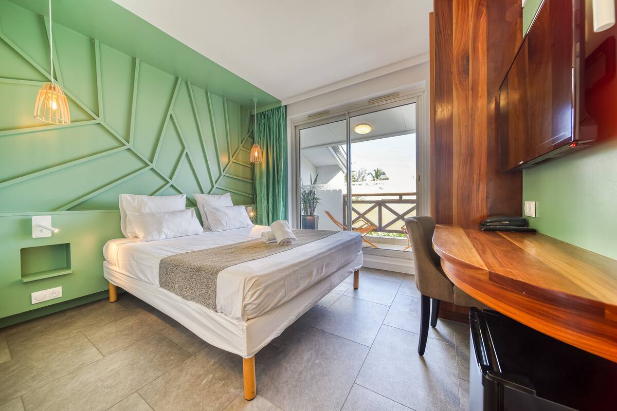 Un dormitorio moderno con una cama, mesita de noche y vistas al exterior.